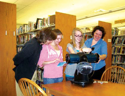 Conway Public Library patrons Janis, Maria, and Jenn take a closer look at the library's new Orion StarBlast 4.5 with Library Director Tara.